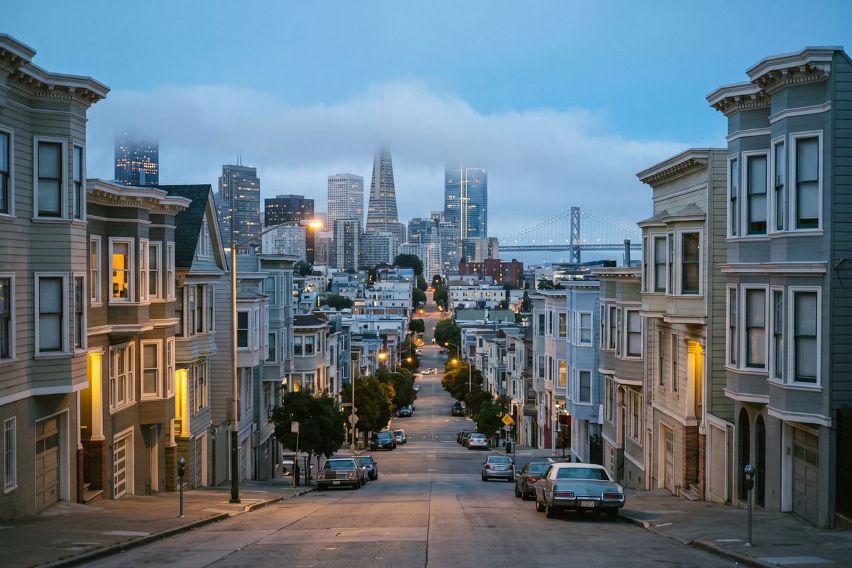 A San Francisco street at blue hour, looking toward downtown and the Bay Bridge